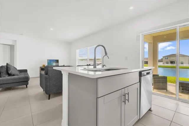 a kitchen with a sink and living room with couches