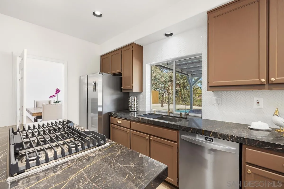 2259 Rolling Ridge Road Chula Vista, CA 91914 - Photo 18 of 52 a kitchen with stainless steel appliances granite countertop a sink stove and refrigerator