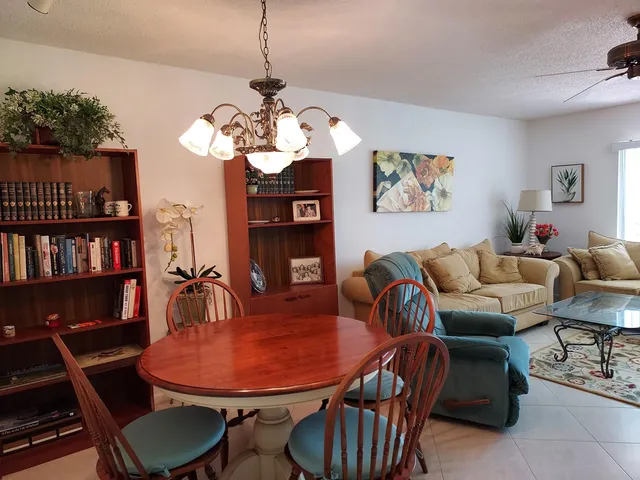 a living room with furniture a bookshelf and a chandelier