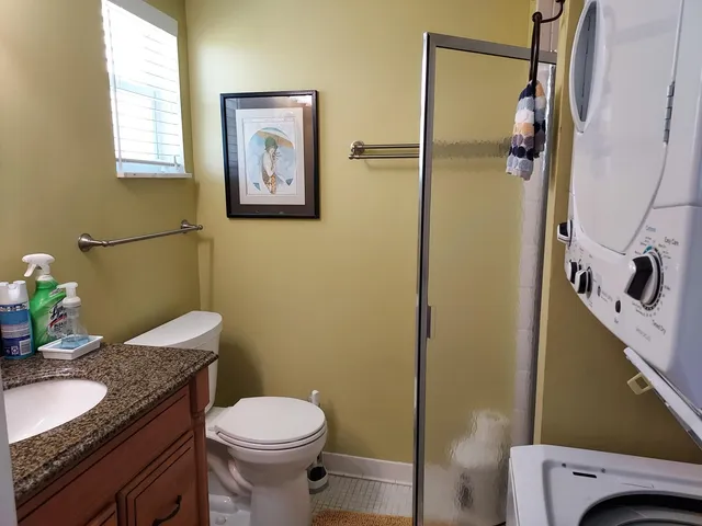 a bathroom with a granite countertop toilet sink and mirror