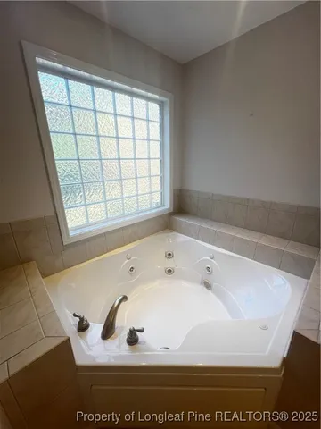 a spacious bathroom with a double vanity sink a mirror and a bathtub
