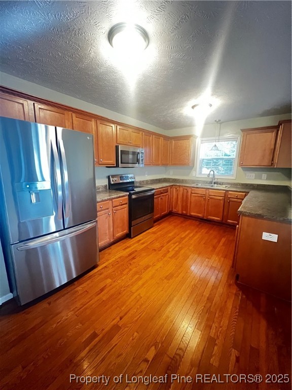 208 Wood Run Sanford, NC 27332 - Photo 5 of 29 a kitchen with stainless steel appliances granite countertop a refrigerator a sink dishwasher a stove and white countertops with wooden floor