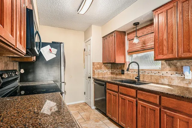 a kitchen with stainless steel appliances granite countertop a sink stove and cabinets