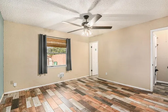 a view of a room with a ceiling fan and a window