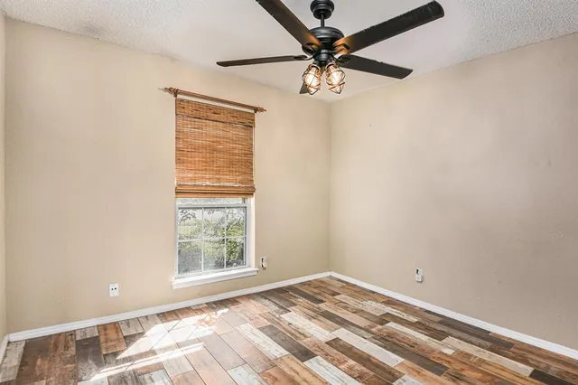 an empty room with a window and a fan