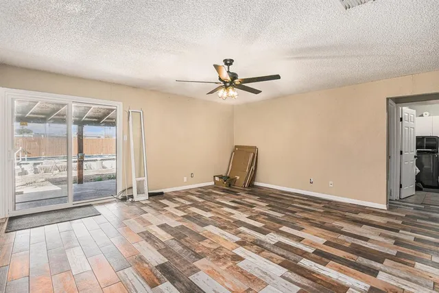a view of a livingroom with a chandelier fan and wooden floor