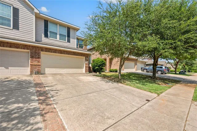 a front view of a house with a yard and trees