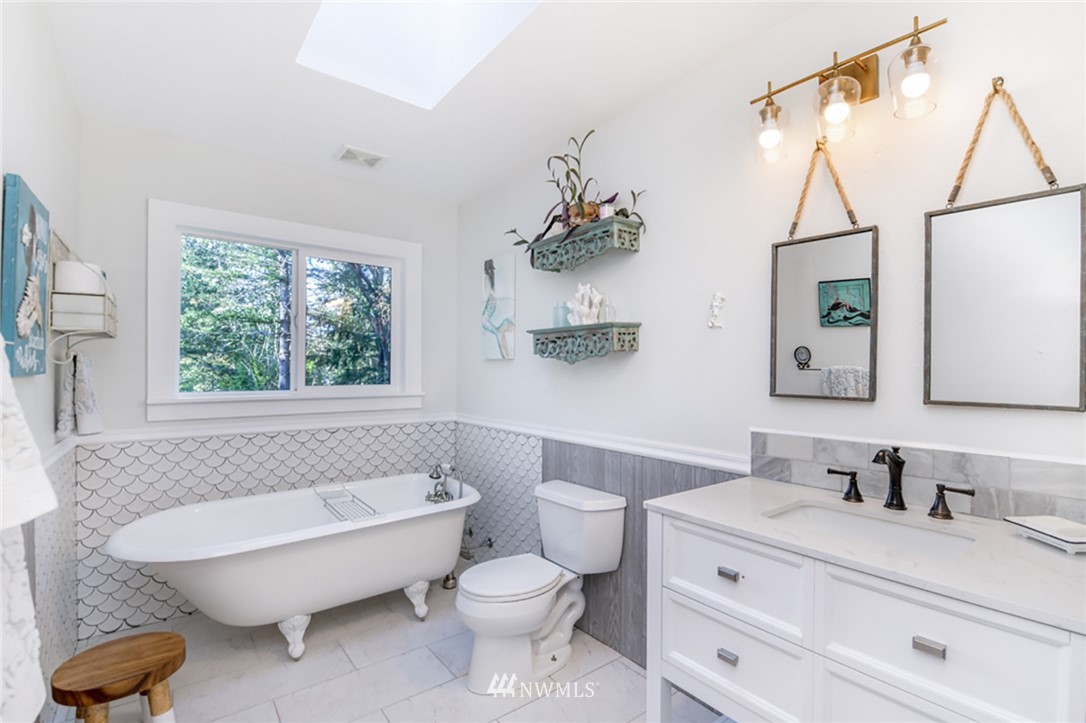 2507 Rocky Point Road Northwest Bremerton, WA 98312 - Photo 12 of 31 a bathroom with a granite countertop toilet sink and mirror