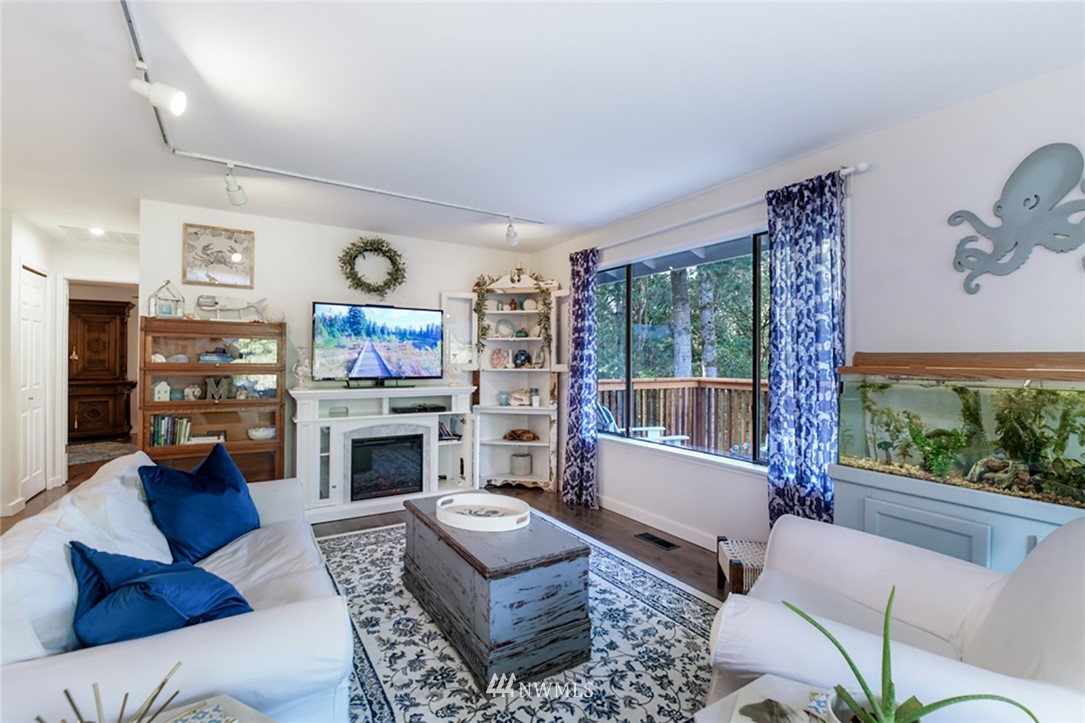 2507 Rocky Point Road Northwest Bremerton, WA 98312 - Photo 3 of 31 a living room with furniture a flat screen tv and a fireplace