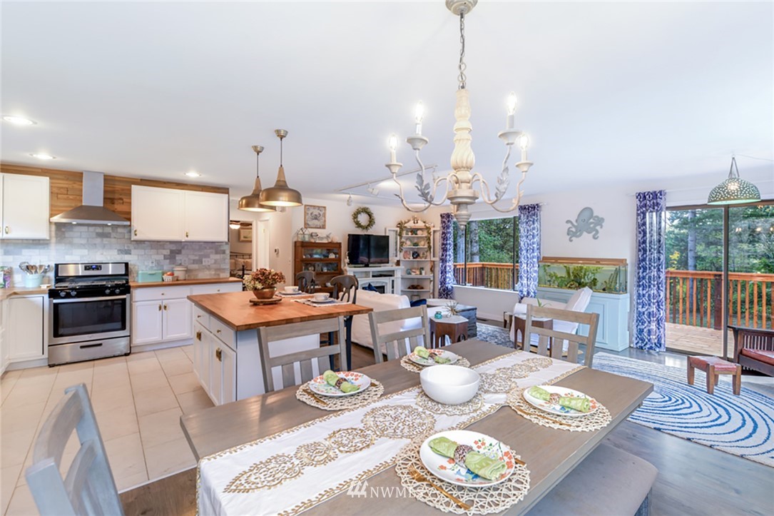 2507 Rocky Point Road Northwest Bremerton, WA 98312 - Photo 9 of 31 a open kitchen with granite countertop a stove a sink a dining table and chairs with wooden floor