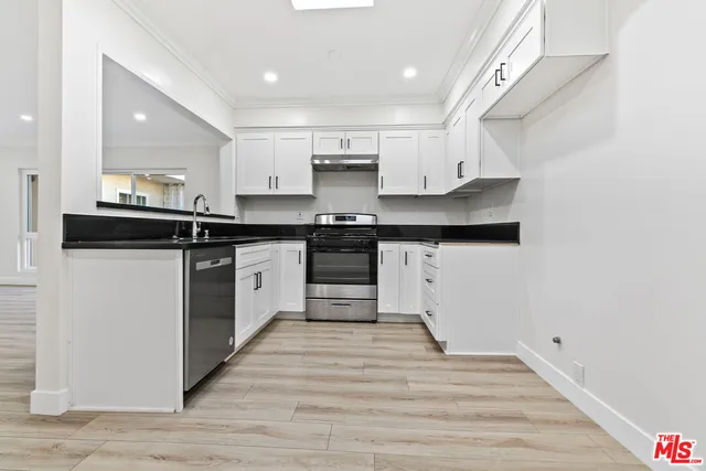 a kitchen with granite countertop white cabinets and a stove