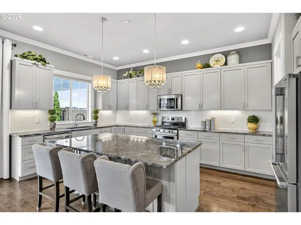 a kitchen with kitchen island granite countertop a table chairs sink and cabinets
