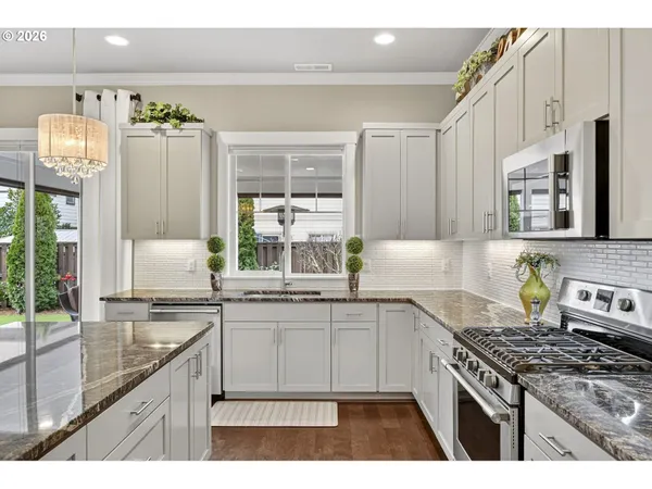 a kitchen with stainless steel appliances granite countertop a sink stove and refrigerator