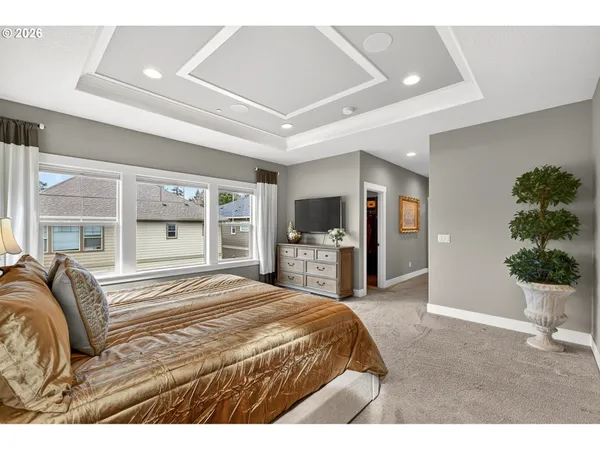 a spacious bedroom with a large bed and potted plant