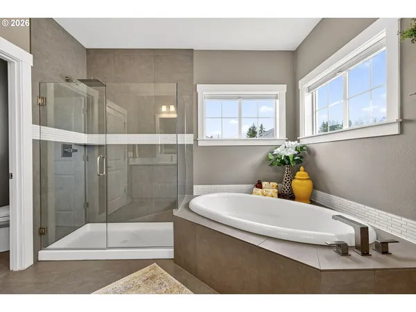 a bathroom with a tub a potted plant a sink and a shower