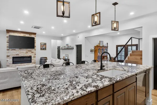 a kitchen with stainless steel appliances granite countertop a sink a stove and a wooden cabinets