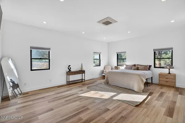 a spacious bedroom with a bed a couch and a desk