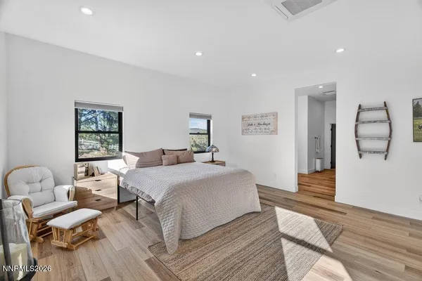 a bedroom with a bed and wooden floor
