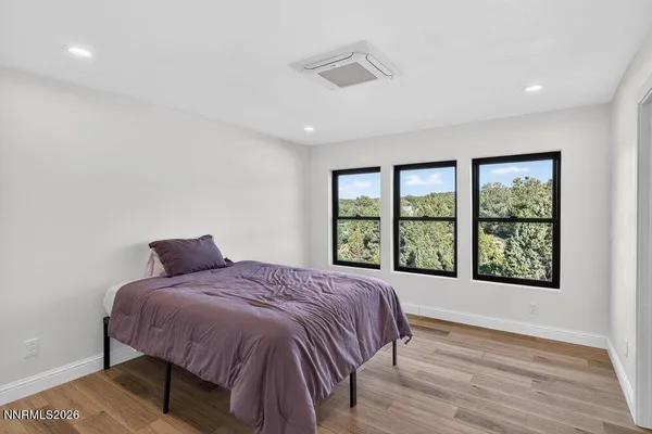 a bedroom with a bed and a large window