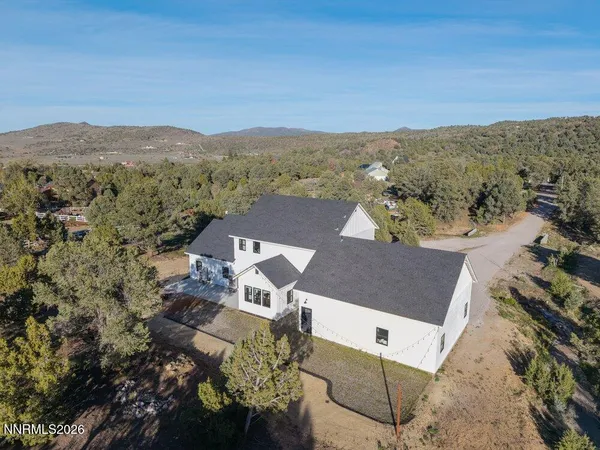 an aerial view of a house with a mountain