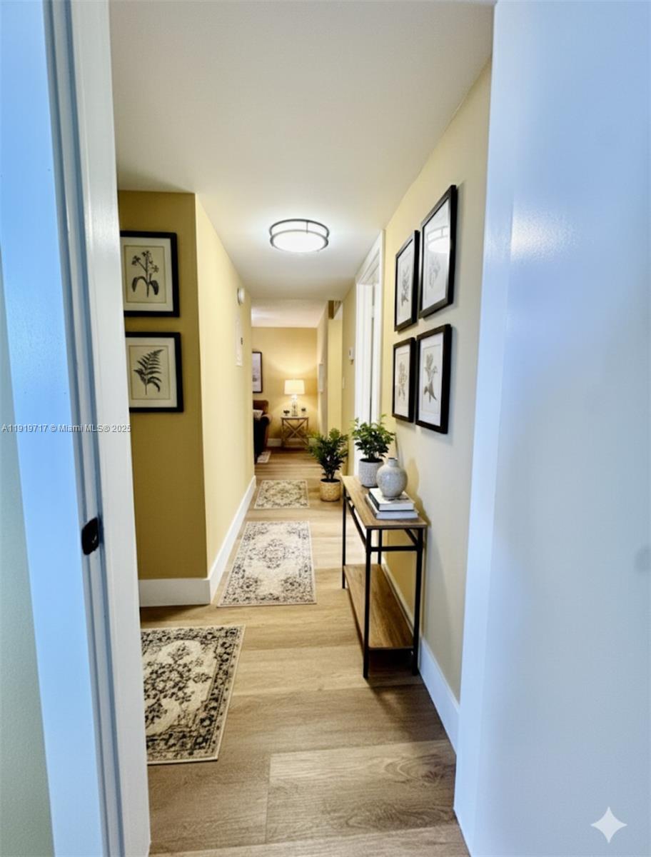 10985 Southwest 107th Street, Unit 216 Miami, FL 33176 - Photo 15 of 39 a view of a hallway to a livingroom with furniture wooden floor and windows
