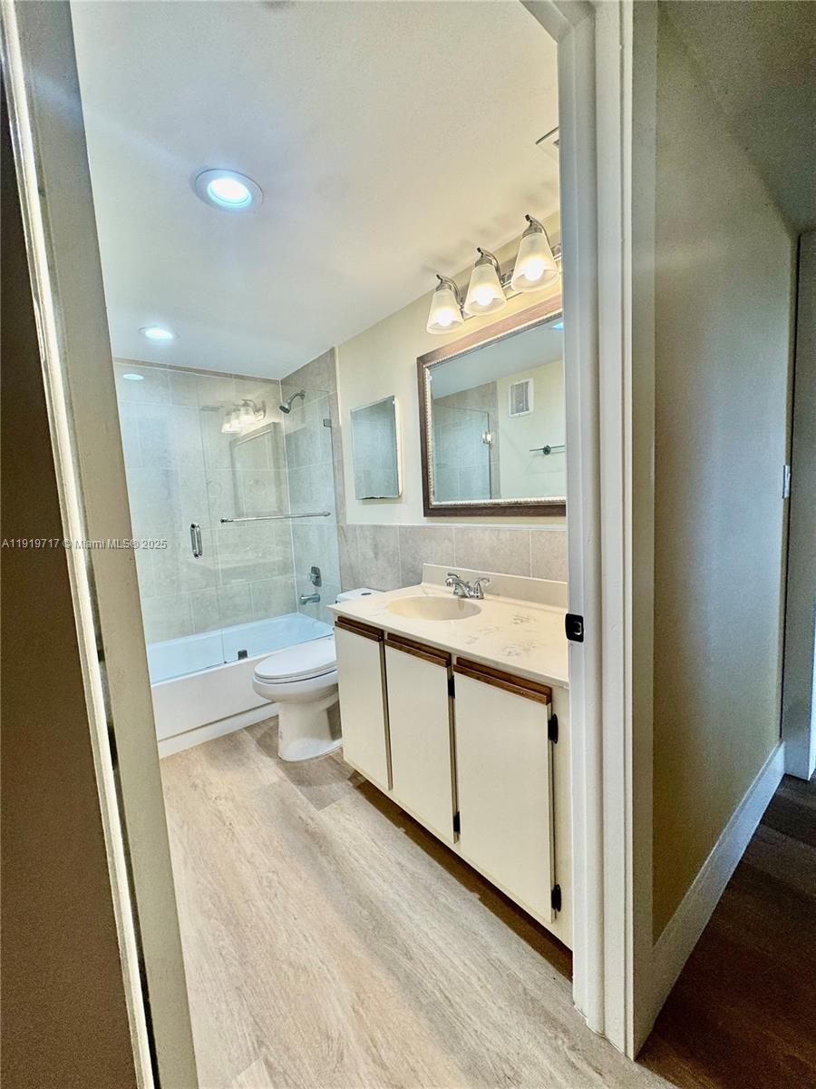 10985 Southwest 107th Street, Unit 216 Miami, FL 33176 - Photo 21 of 39 a bathroom with a double vanity sink toilet mirror and bathtub