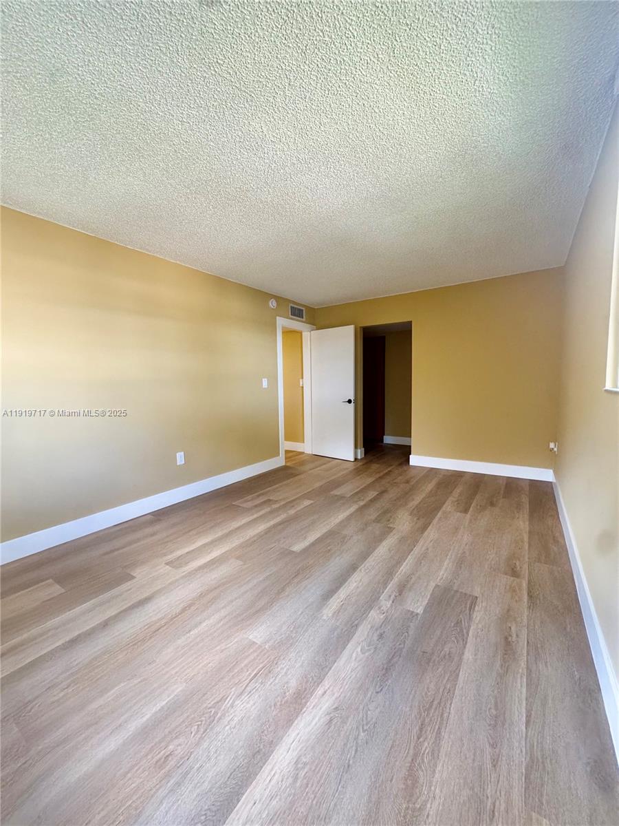 10985 Southwest 107th Street, Unit 216 Miami, FL 33176 - Photo 30 of 39 a view of an empty room with wooden floor