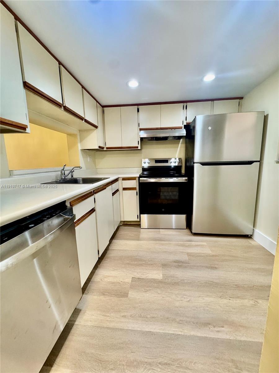 10985 Southwest 107th Street, Unit 216 Miami, FL 33176 - Photo 7 of 39 a kitchen with stainless steel appliances granite countertop a refrigerator a stove a sink dishwasher and a refrigerator