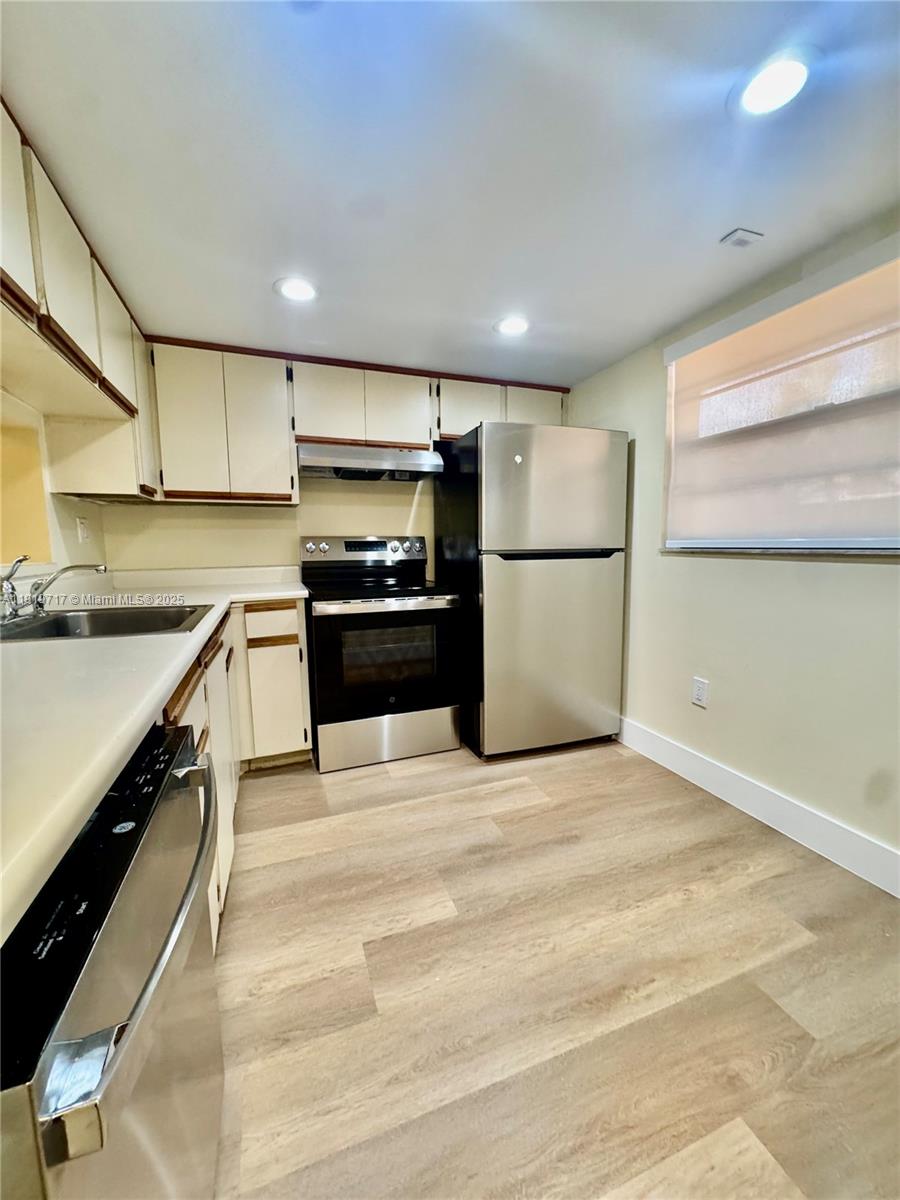 10985 Southwest 107th Street, Unit 216 Miami, FL 33176 - Photo 8 of 39 a kitchen with kitchen island a stove a sink and a refrigerator