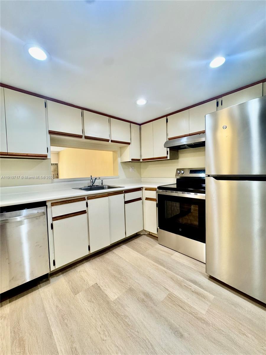 10985 Southwest 107th Street, Unit 216 Miami, FL 33176 - Photo 9 of 39 a kitchen with granite countertop stainless steel appliances and white cabinets