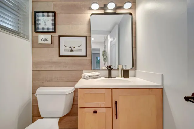 a bathroom with a toilet sink and mirror