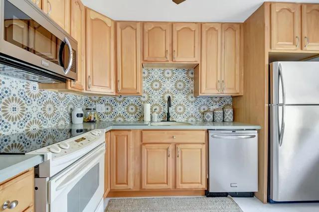 a kitchen with stainless steel appliances granite countertop a refrigerator sink and cabinets