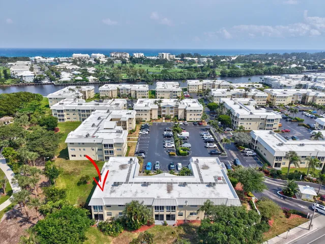 a large white kitchen with granite countertop a sink window and cabinets