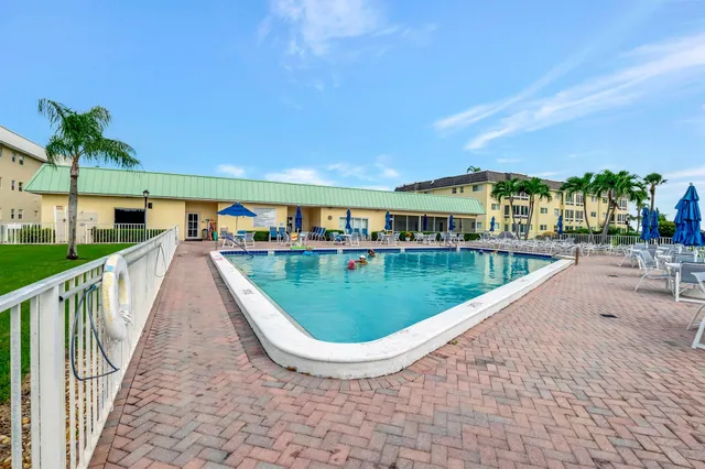 a view of a house with a yard and potted plants
