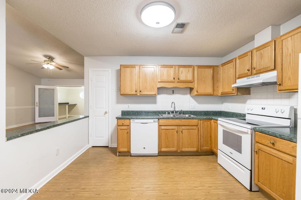 114 Wesleyan Way Macon, GA 31210 - Photo 11 of 28 a kitchen with granite countertop a sink cabinets stainless steel appliances and a window