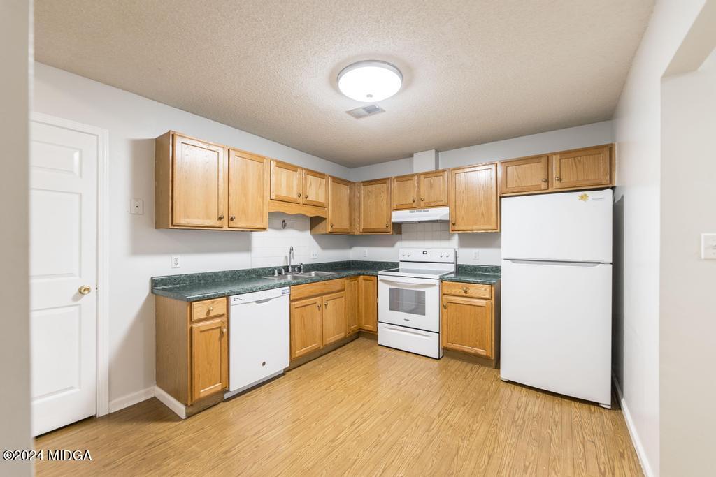 114 Wesleyan Way Macon, GA 31210 - Photo 10 of 28 a kitchen with stainless steel appliances granite countertop a refrigerator a sink dishwasher a stove with wooden cabinets and floor