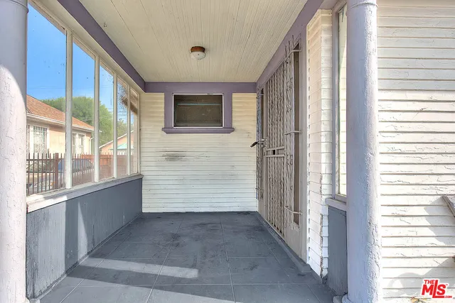 a view of a porch with a door and wooden floor
