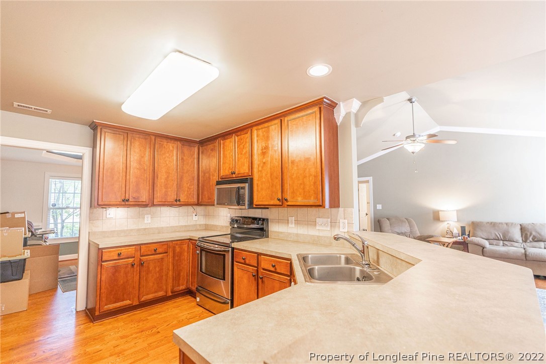 465 Booth Pond Road Raeford, NC 28376 - Photo 8 of 25 a kitchen with a sink stove and wooden cabinets