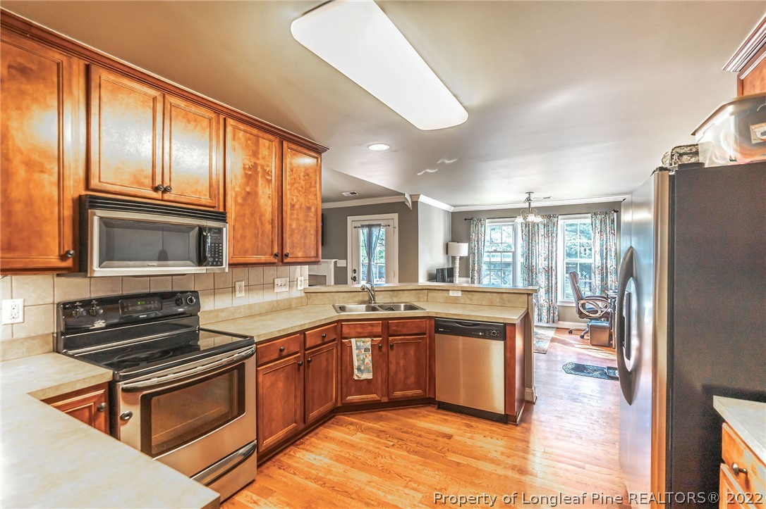 465 Booth Pond Road Raeford, NC 28376 - Photo 9 of 25 a large kitchen with stainless steel appliances granite countertop a stove refrigerator and cabinets
