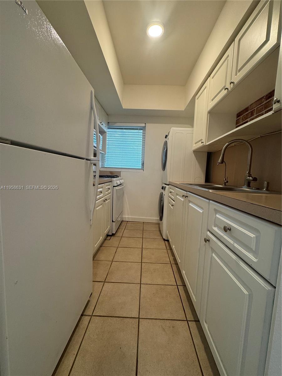 921 Meridian Avenue, Unit 7 Miami Beach, FL 33139 - Photo 17 of 33 a kitchen with stainless steel appliances a sink and cabinets