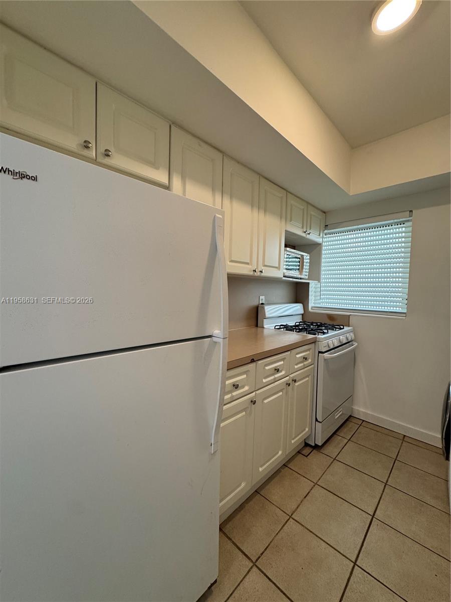 921 Meridian Avenue, Unit 7 Miami Beach, FL 33139 - Photo 27 of 33 a kitchen with a refrigerator sink and cabinets