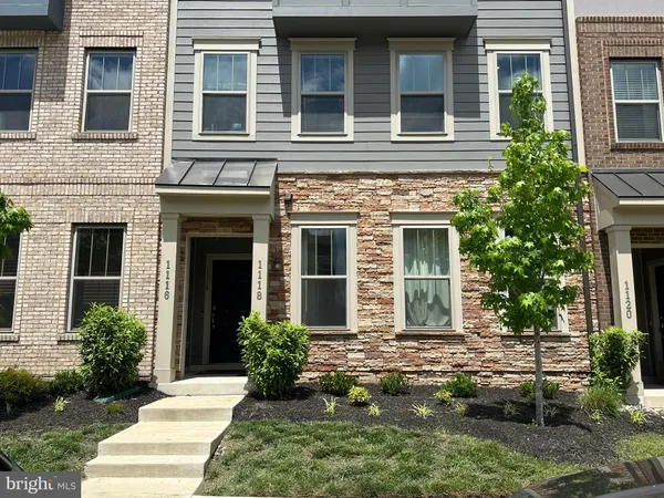a view of a house with brick walls and a yard