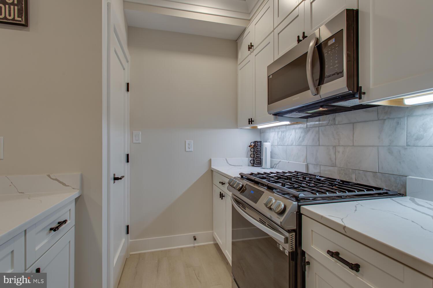 3554 13th Street Northwest, Unit 1 Washington, DC 20010 - Photo 12 of 25 a kitchen with stainless steel appliances white cabinets and a stove top oven