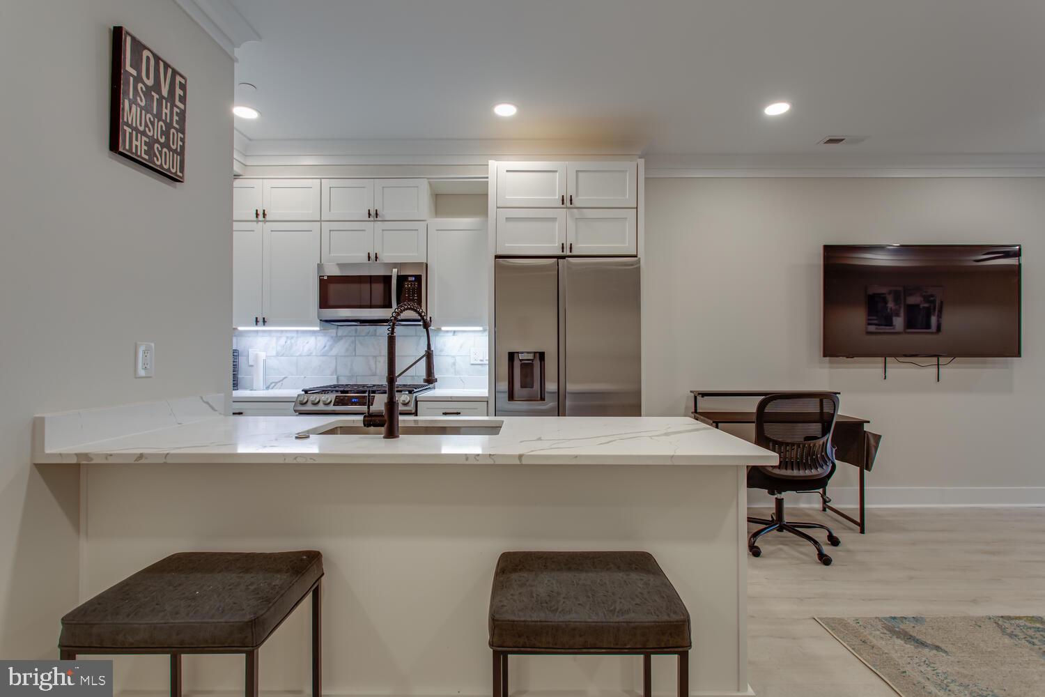 3554 13th Street Northwest, Unit 1 Washington, DC 20010 - Photo 14 of 25 a kitchen with kitchen island a sink cabinets and stainless steel appliances