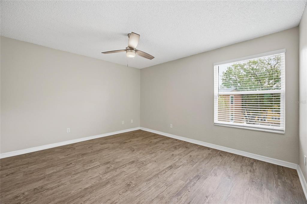 4532 Commander Drive, Unit 2132 Orlando, FL 32822 - Photo 17 of 26 a view of an empty room with wooden floor and a window