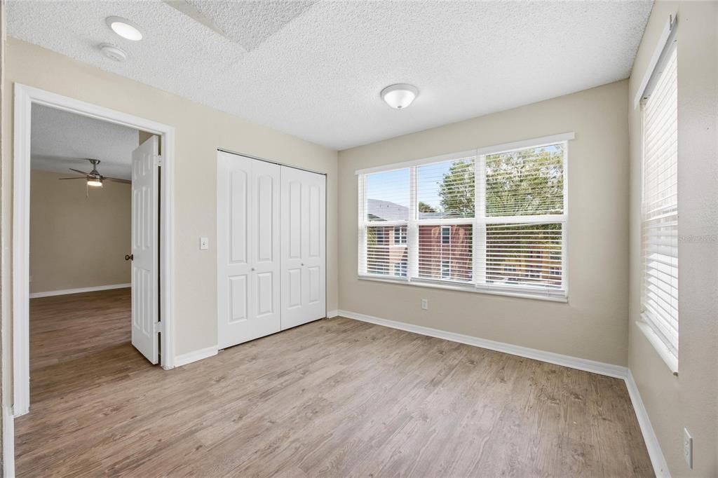 4532 Commander Drive, Unit 2132 Orlando, FL 32822 - Photo 8 of 26 an empty room with wooden floor and windows