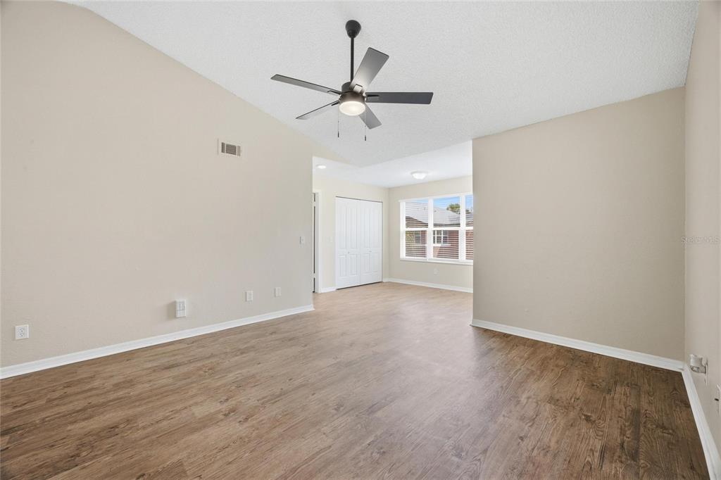 4532 Commander Drive, Unit 2132 Orlando, FL 32822 - Photo 10 of 26 wooden floor in an empty room with a window