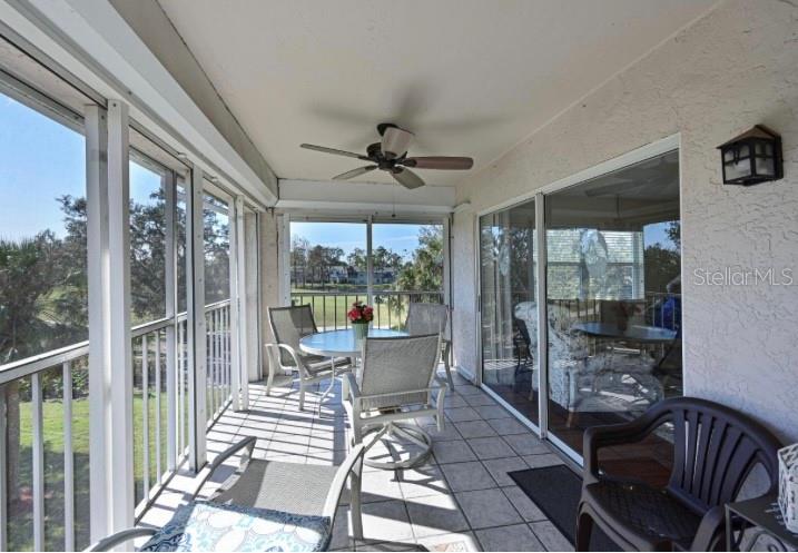 6501 Stone River Road, Unit 303 Bradenton, FL 34203 - Photo 13 of 30 a living room with a floor to ceiling window and a table