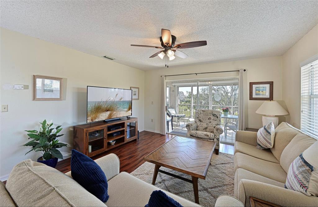 6501 Stone River Road, Unit 303 Bradenton, FL 34203 - Photo 3 of 30 a living room with furniture and a flat screen tv