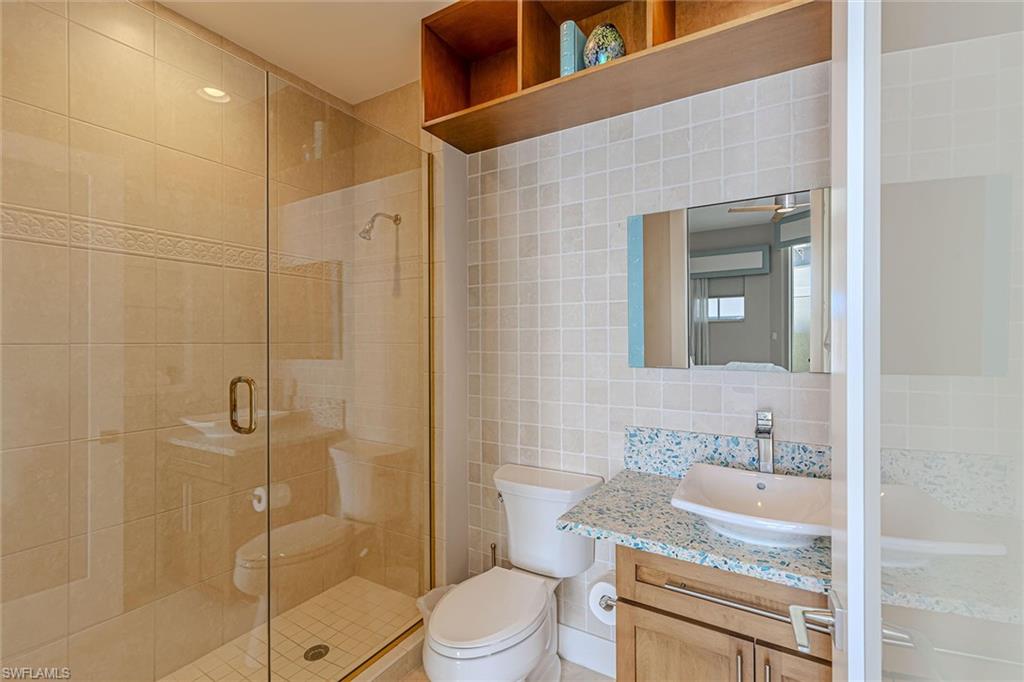 295 Grande Way, Unit PH2 Naples, FL 34110 - Photo 15 of 45 a bathroom with a granite countertop sink toilet and shower